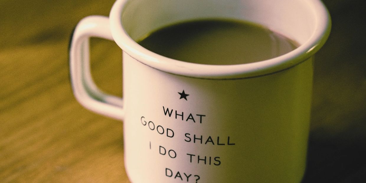A white mug with an inspirational quote filled with coffee.