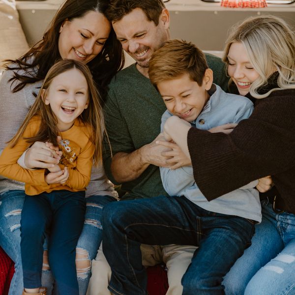 A joyful family laughing and cuddling together on a couch.