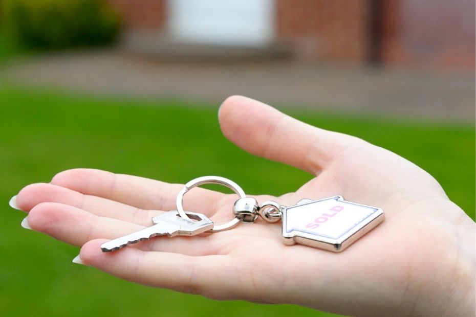 A hand holding a key and key ring