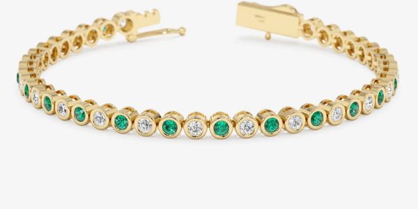 Gold bracelet with alternating green and white gemstones.