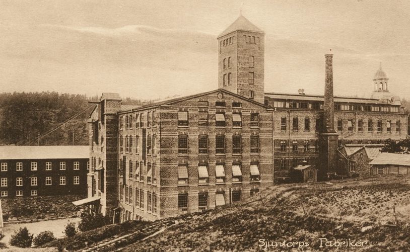 Historic sepia-toned photo of an old industrial building complex.