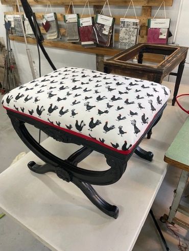 A black wooden stool with a white cushion featuring black bird prints.