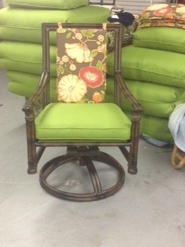 Wooden chair with green cushions and floral backrest in a storage setting.