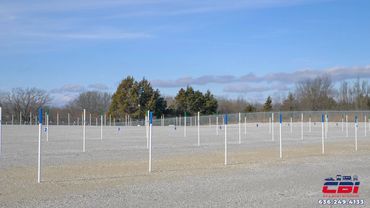 Empty RV and boat storage lot with numbered white poles under a clear blue sky.