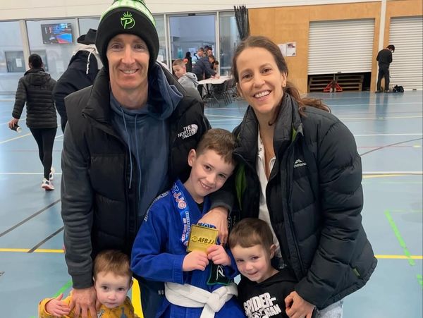 Family celebrating a young boy's achievement indoors.