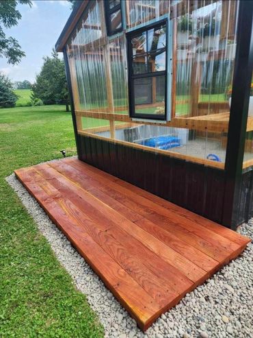 front wood patio of a custom made greenhouse shed