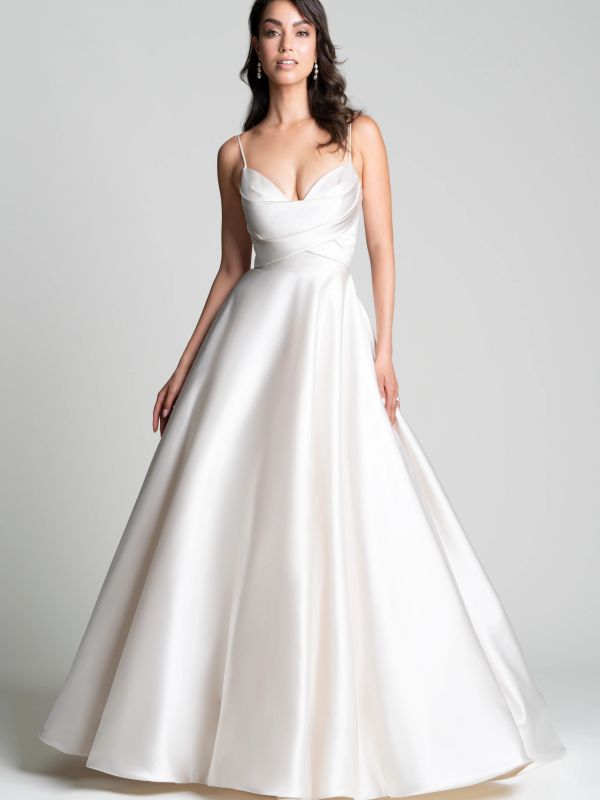 Elegant woman in a satin white gown with thin straps.