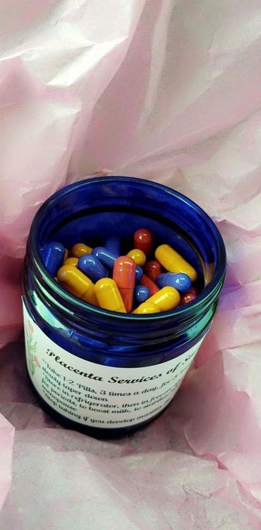 Blue jar filled with colorful capsules on pink tissue paper.