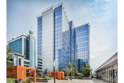 Modern glass office building with blue sky.