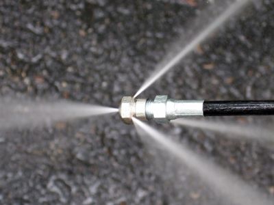 Close-up of a pressure washer nozzle spraying water in multiple jets.