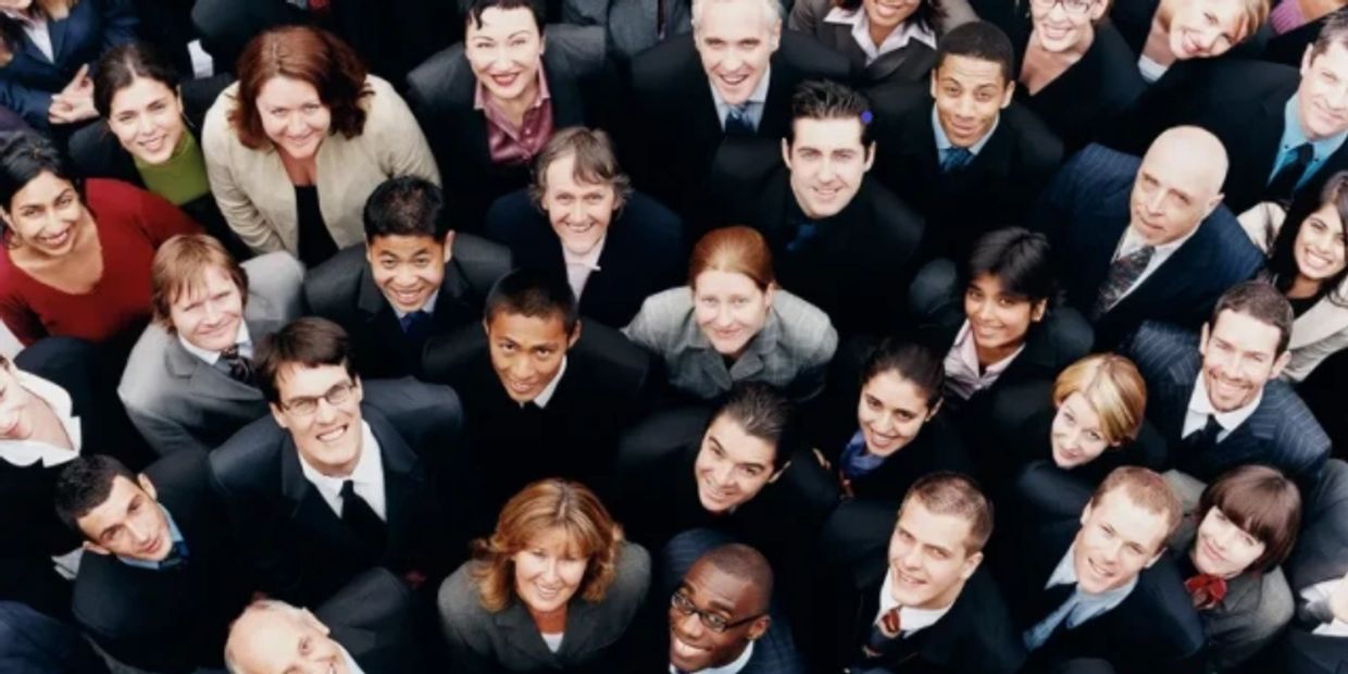 The image shows a crowd of people look upward as a representation of joining a team. 
