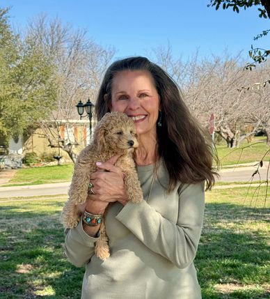 A woman holding her new Goldendoodle puppy.