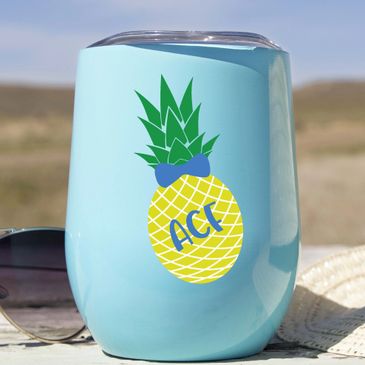 Wine Stainless Steel Stemless Tumbler on the table with sunglasses and a summer hat.