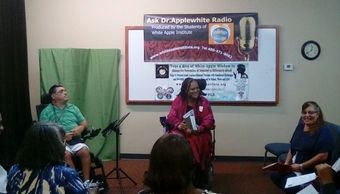 A group discussion at Ask Dr. Applewhite Radio with people seated and engaged.