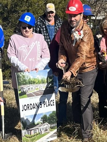 People in hard hats at groundbreaking for Jordan's Place apartments.