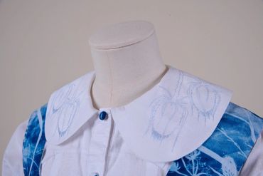 Large round collar of blouse. White cotton finely embroidered in pale blue with teasel plant pattern