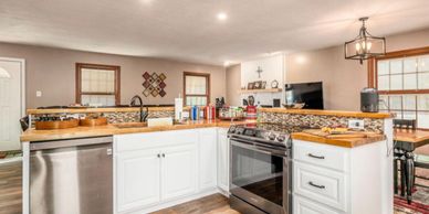 Modern kitchen with white cabinets and stainless steel appliances.