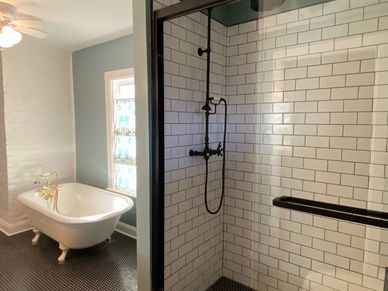 A modern bathroom with a clawfoot tub and a glass-enclosed shower.