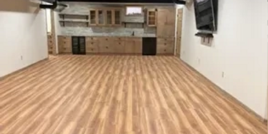 Spacious room with wooden flooring and a kitchenette at the back.