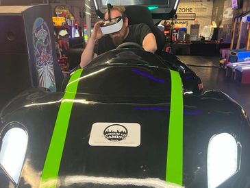 Man wearing VR headset in a racing arcade game car simulator. platinum city gaming photos
platinum gaming