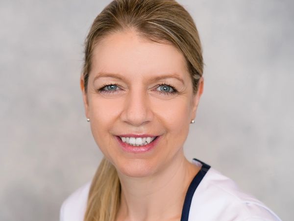 a smiling woman wearing a white shirt.