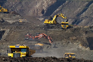 Heavy machinery working in a large open-pit mine.