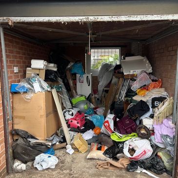 Cluttered garage filled with various boxes, bags, and household items.