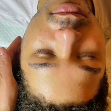 Close-up of a person's face with eyes closed, lying down.