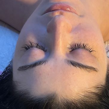 Close-up of a woman's peaceful face with closed eyes and long eyelashes.