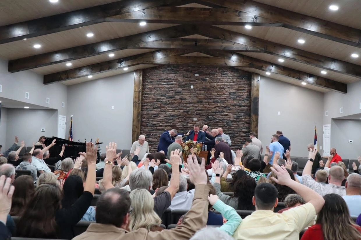 Congregation raising hands in church service.
