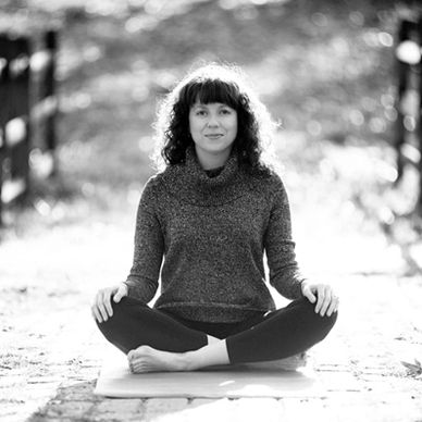 Diane sitting cross-legged at Bryan Park preparing to do Sheng Zhen Qigong.