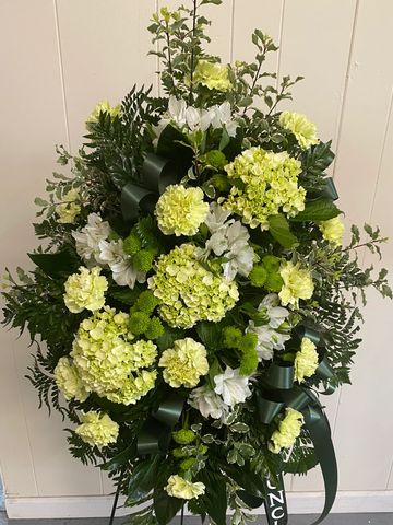 Green and white standing spray. Green hydrangea, mint carnations, green buttons combine to make a be