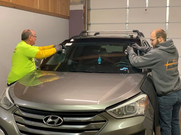 automotive technicians replacing a windshield