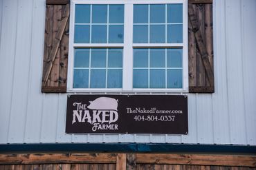 The Naked Farmer sign under the window