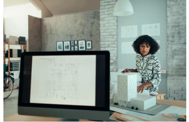 A business woman looking at a building model
