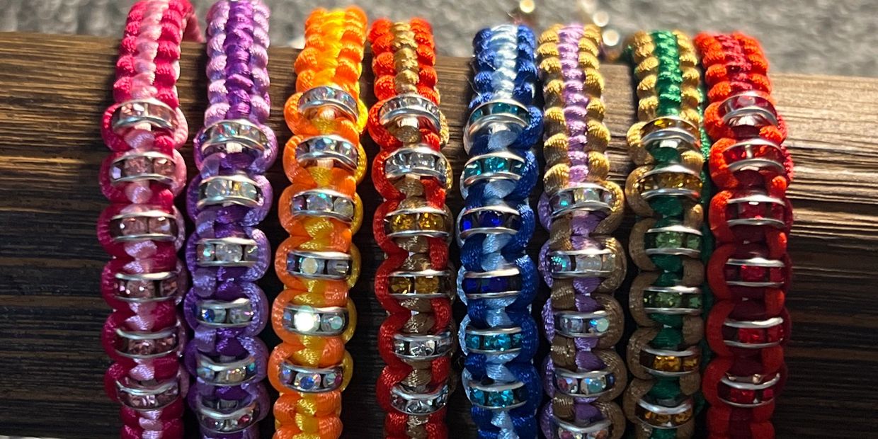 Colorful beaded bracelets lined up on a wooden surface.