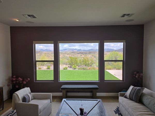 Living room with large windows showcasing a scenic desert mountain view.