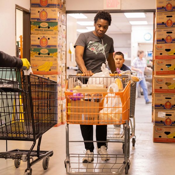 Woman with shopping cart in grocery store aisle