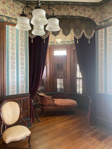 Period appropriate drapery and furniture appoint the Reception Hall, the entrance room of the home.