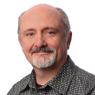 Smiling middle-aged man with a patterned shirt.