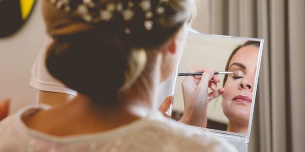 Bride getting her finishing touches done to her bridal makeup and bridal hairstyle