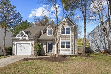 Two-story suburban house with a garage and a tree in the front yard.