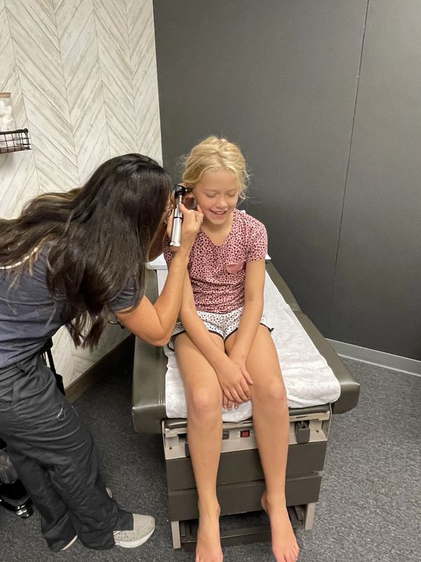 hannah blankespoor checking her daughter brinlee's ears