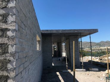 Unfinished brick house under construction with mountain views.