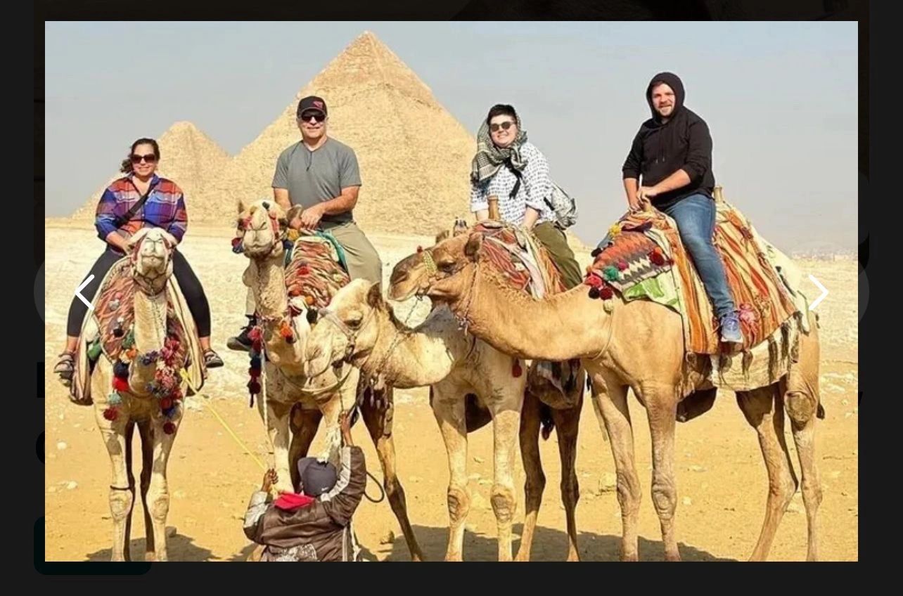 Four tourists riding camels near the pyramids in Egypt on a sunny day.