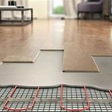 Close-up of underfloor heating system being installed under wooden flooring.