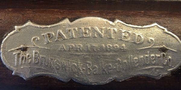 Close-up of a metal patent plaque dated April 1, 1884.