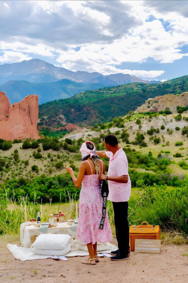 Couple enjoying a picnic with scenic mountain views.