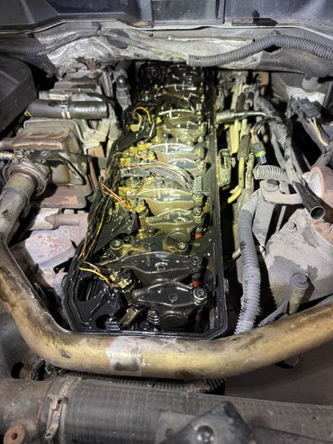 Close-up of an engine with the valve cover removed showing rocker arms and wiring.