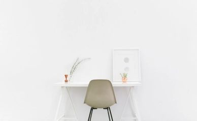 How I Became A Minimalist Overnight - A desk with minimal decor and beige chair